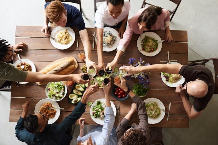Group of friends toasting at dinner — why group travel is better when you plan together